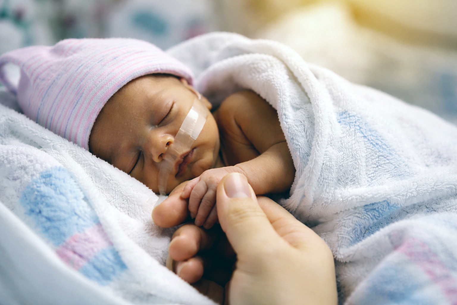 A tiny hand held with care